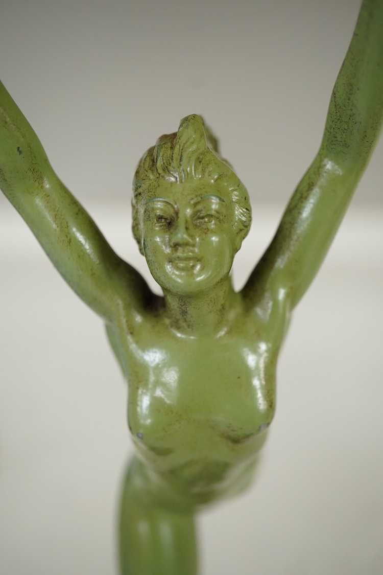 An Art Deco patinated spelter figurine of a nude dancer raised on black and green onyx base, 29cm high